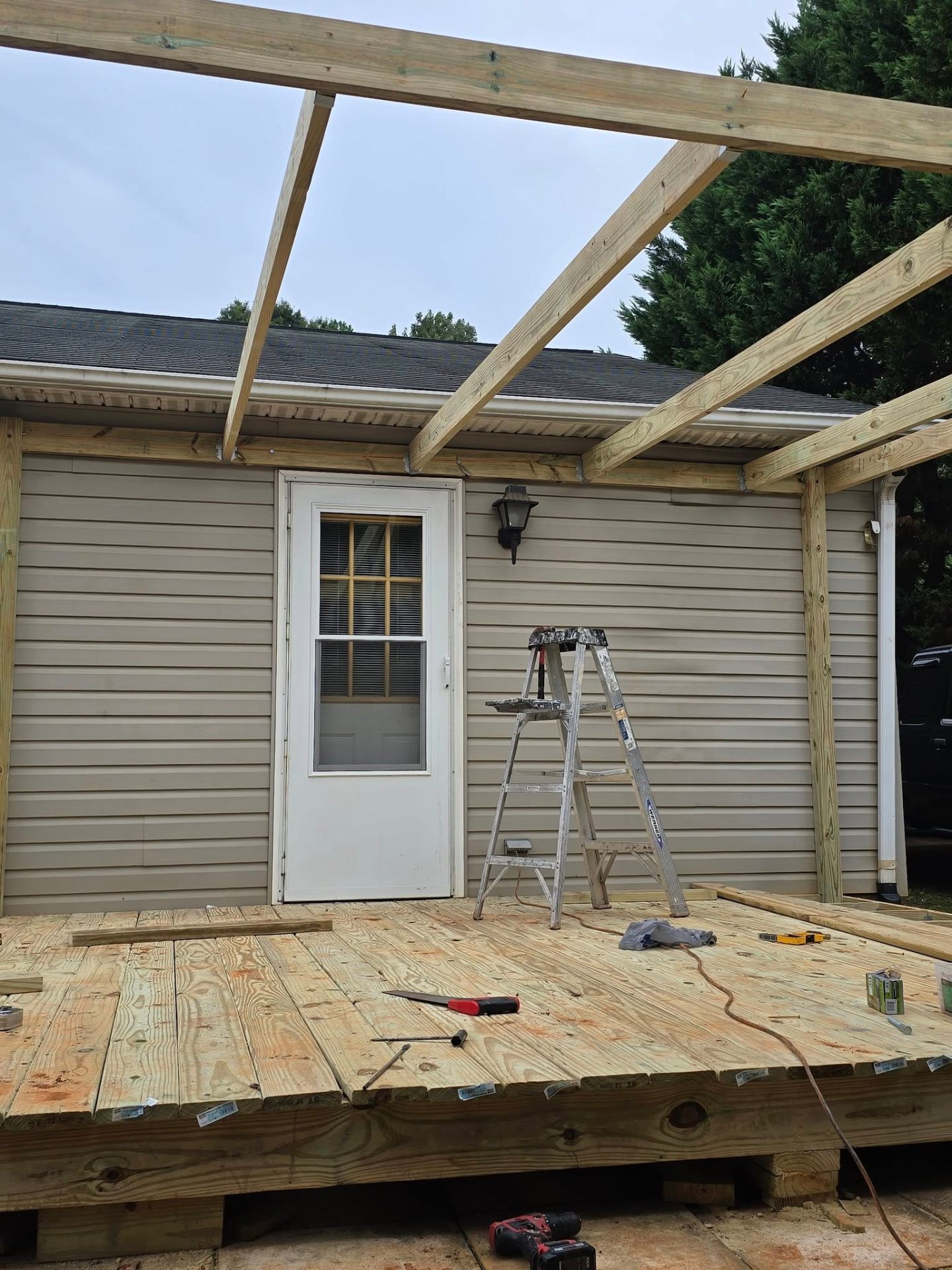 Fresh deck and overhead beams in place against the home